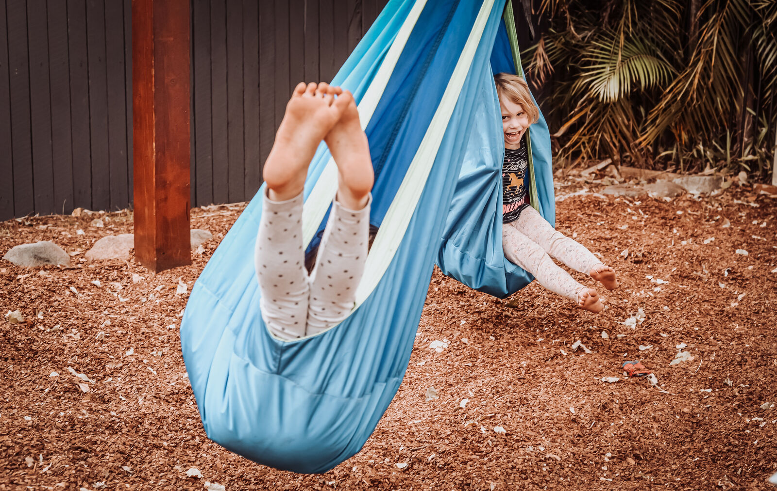 Two children swinging in pod swings
